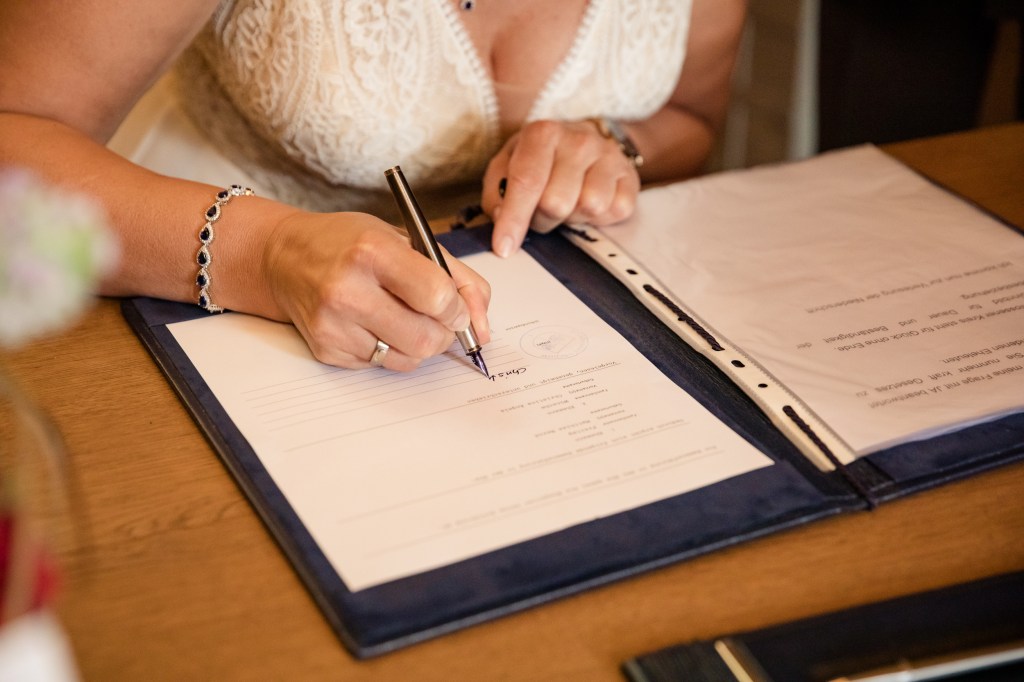 Braut unterschreibt die Eheurkunde in den Koserower Salzhütten