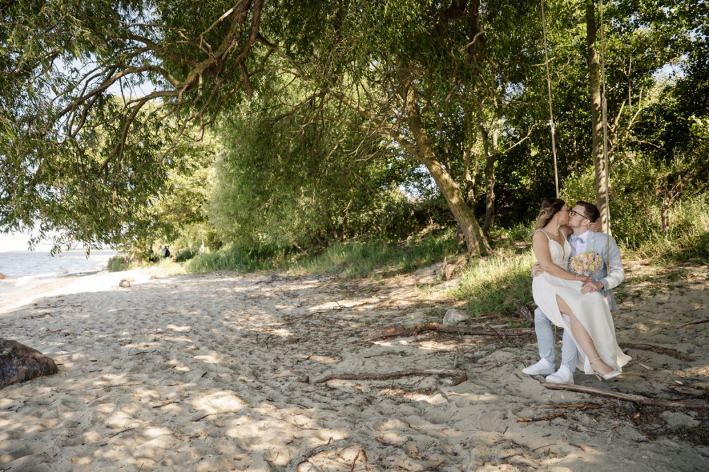 Marina und Tom schaukelnd am Hochzeitstag. Ein romantisches Hochzeitsfoto einer perfekten Ostseehochzeit.