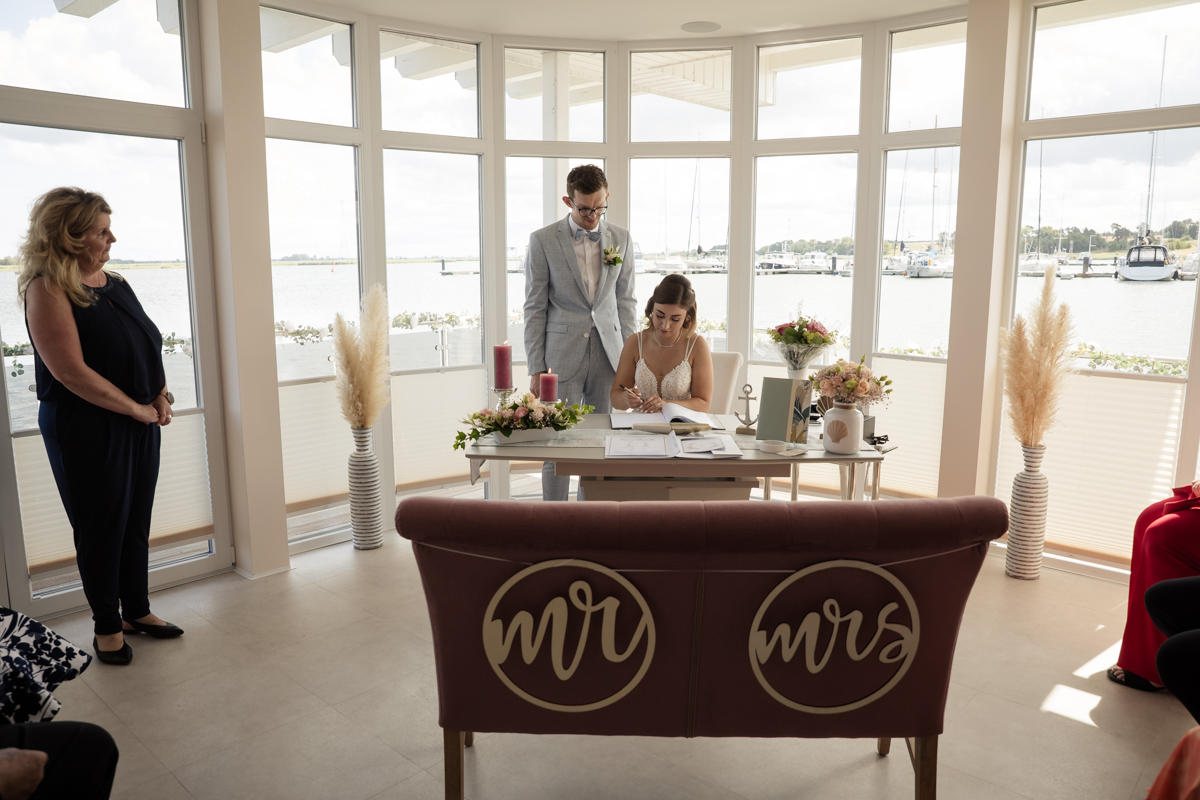 Marina und Tom unterschreiben die Eheurkunde im Standesamt Lubmin