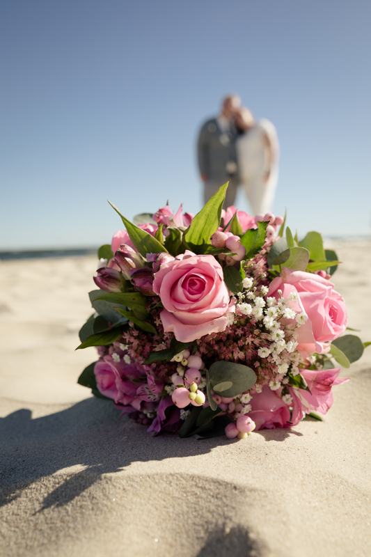Brautstrauß mit rosa Ranunkeln und Eukalyptus im Sand am Strand von Ahlbeck